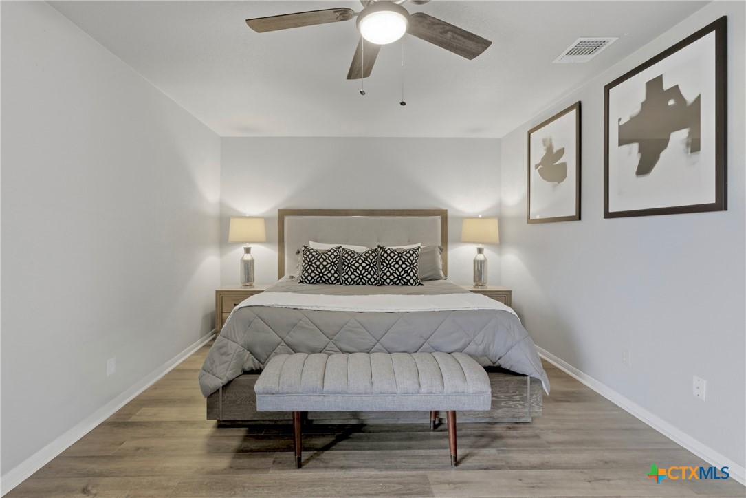 1710 Old Mill Road, Unit 12 Salado, TX 76571 - Photo 25 of 42 a bedroom with a bed and a painting on the wall