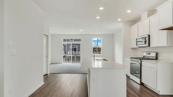 a kitchen with stainless steel appliances granite countertop a stove a sink and a refrigerator with wooden floor
