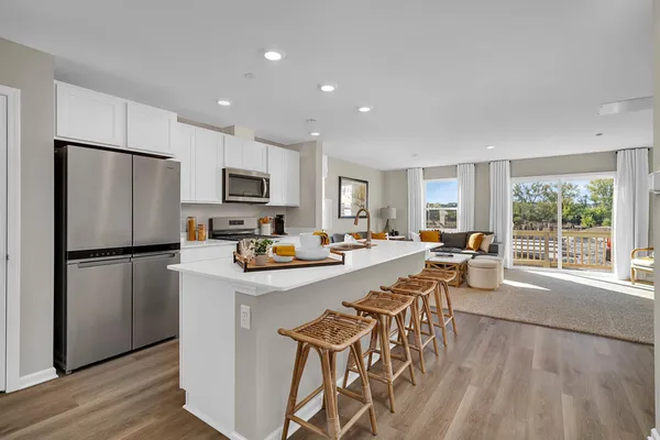 a kitchen with refrigerator a table and chairs