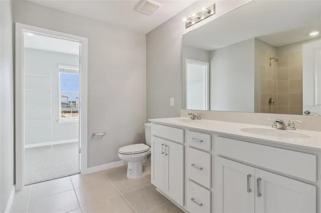 a bathroom with a double vanity sink a toilet and a mirror