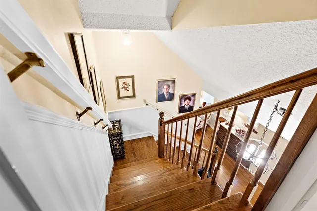 a view of staircase with railing and white walls