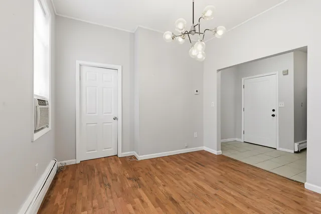 wooden floor in an empty room with a chandelier fan