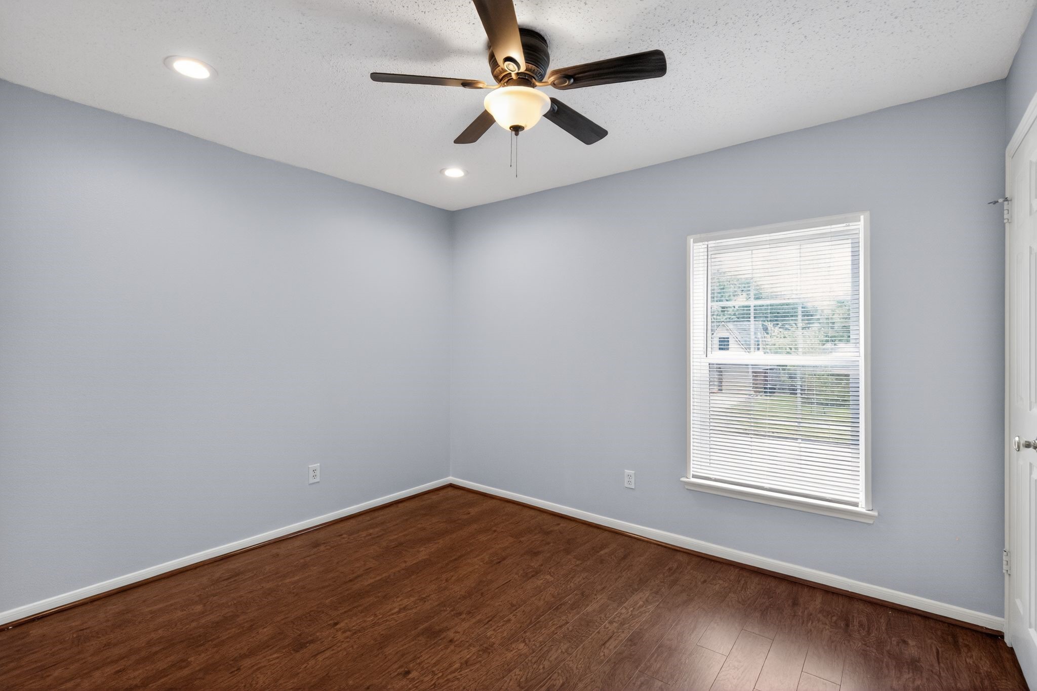 918 Long Prairie Drive Katy, TX 77450 - Photo 16 of 30 an empty room with wooden floor chandelier fan and windows