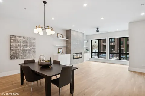 a kitchen with stainless steel appliances granite countertop a table chairs in it and wooden floors