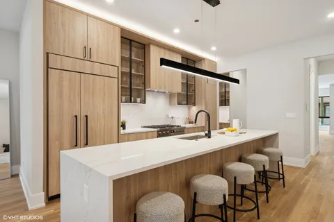 a kitchen with a sink stove and wooden floor