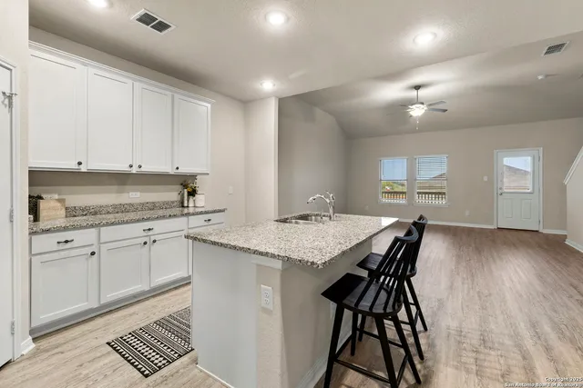 a kitchen with granite countertop white cabinets and appliances
