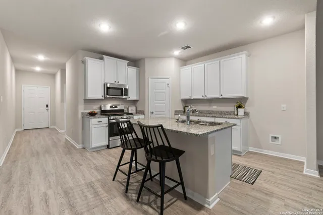 a kitchen with stainless steel appliances a stove a sink and a refrigerator