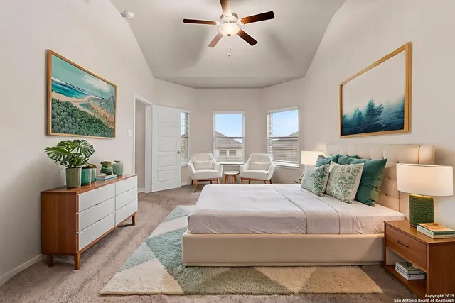 a bedroom with a large bed and a chandelier fan