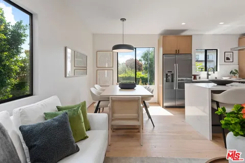 a dining room with furniture a chandelier and wooden floor