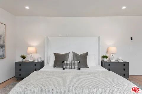 a bedroom with a bed and a lamp on dresser