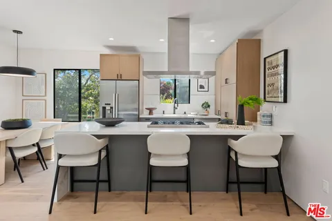 a kitchen with a sink and chairs
