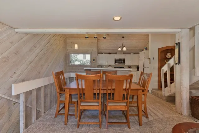 a kitchen with a dining table chairs and refrigerator