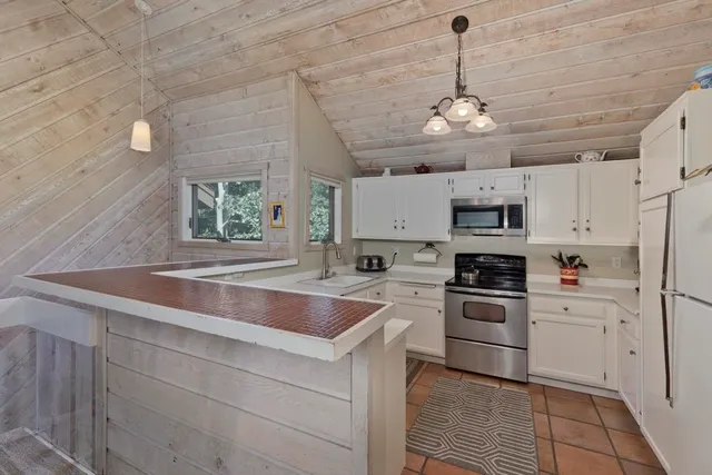 a kitchen with cabinets stainless steel appliances and a window