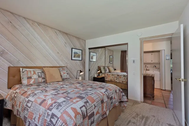 a bedroom with a large bed and a chandelier