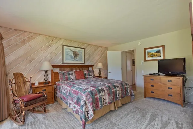 a bedroom with a bed and a chair in it