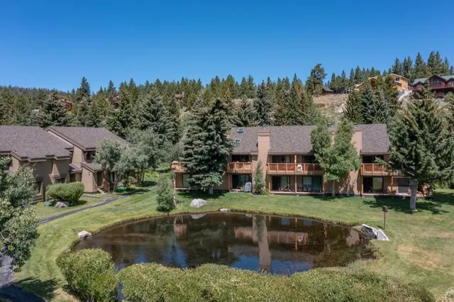 an aerial view of a house with garden space and trees all around