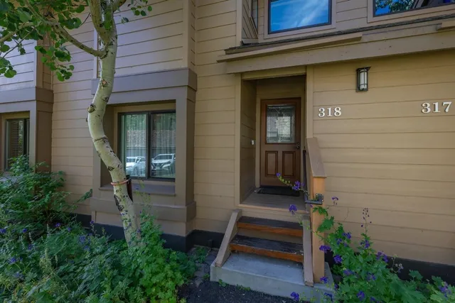 a view of a wooden door of the house with a bench