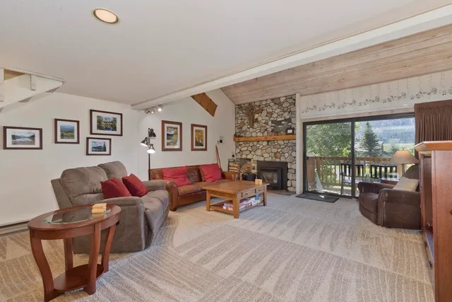 a living room with furniture a fireplace and a floor to ceiling window