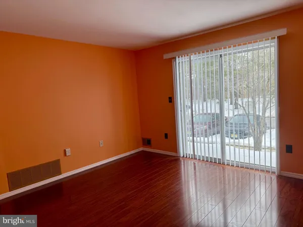 a view of a big room with wooden floor and windows