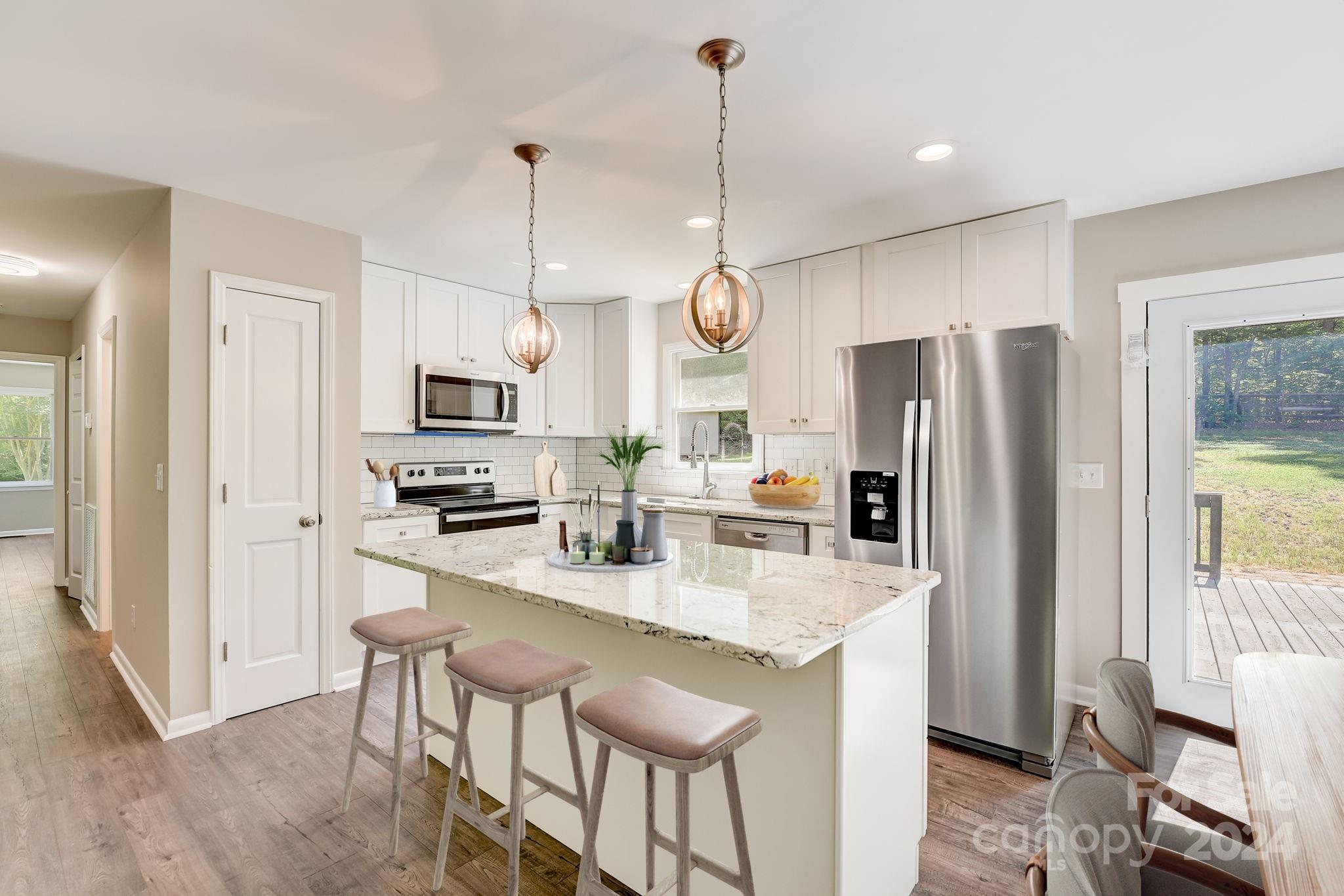 16218 Barbee Road Stanfield, NC 28163 - Photo 11 of 48 a kitchen with stainless steel appliances granite countertop a refrigerator a oven a sink a stove a dining table and chairs