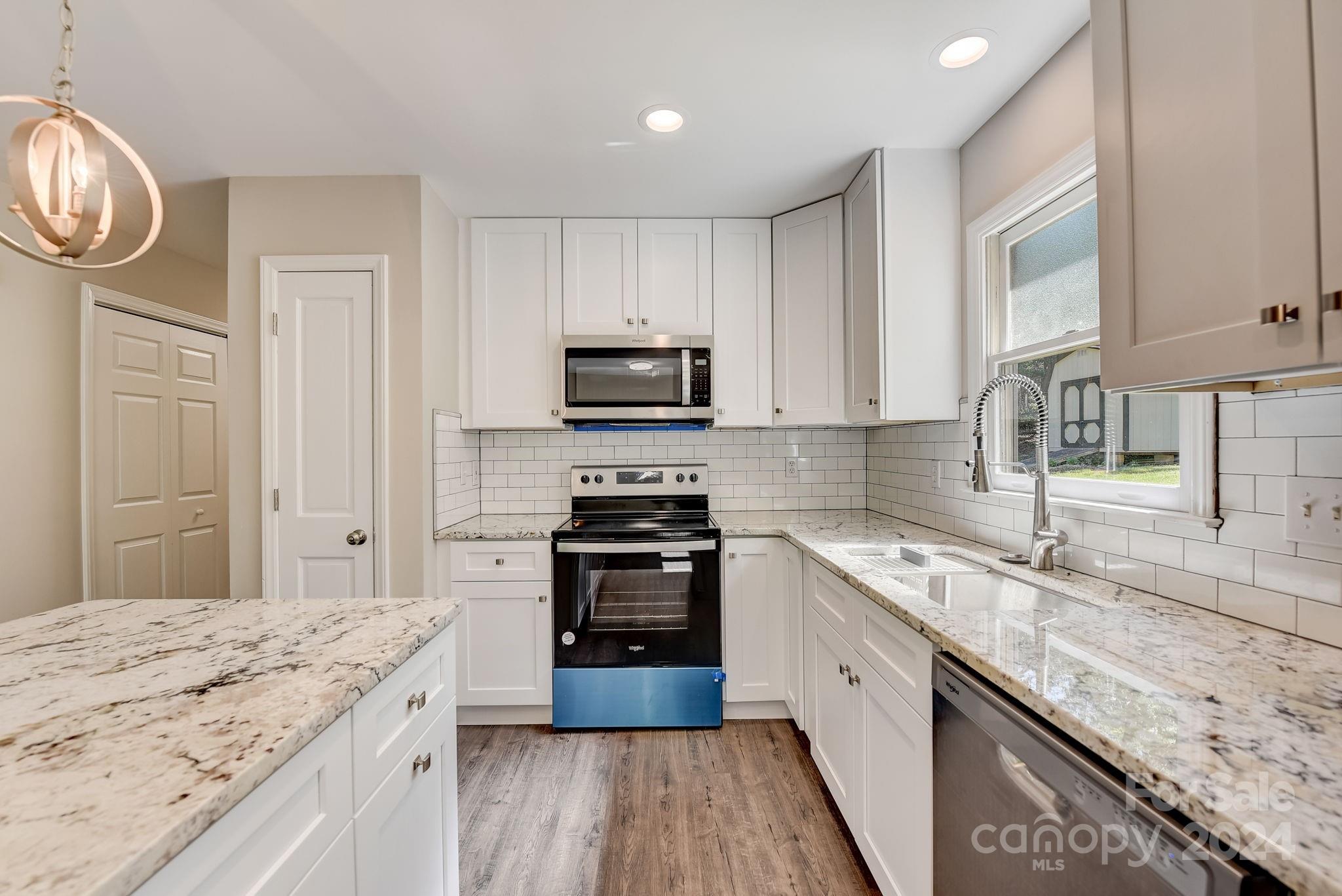 16218 Barbee Road Stanfield, NC 28163 - Photo 15 of 48 a kitchen with granite countertop stainless steel appliances a stove microwave and sink