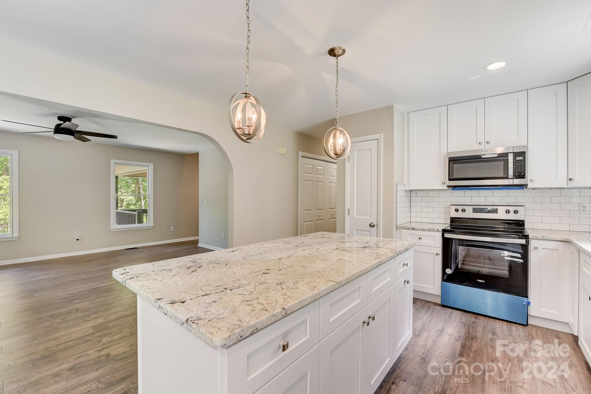 16218 Barbee Road Stanfield, NC 28163 - Photo 16 of 48 a kitchen with stainless steel appliances granite countertop a stove oven and a sink with granite countertops