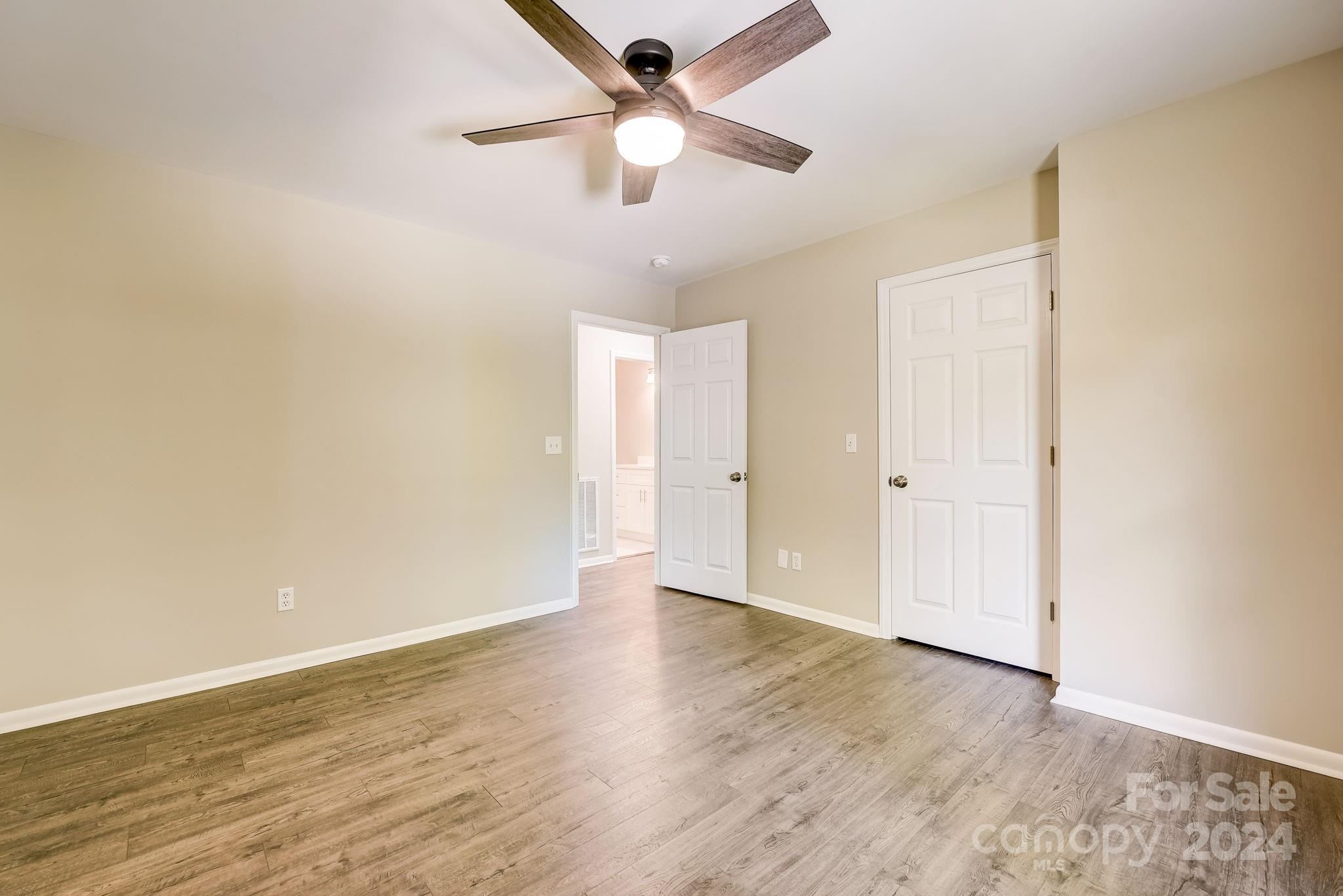 16218 Barbee Road Stanfield, NC 28163 - Photo 20 of 48 an empty room with wooden floor ceiling fan and window