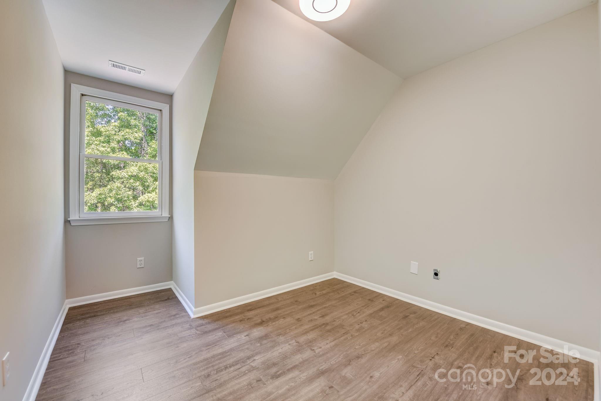 16218 Barbee Road Stanfield, NC 28163 - Photo 28 of 48 an empty room with wooden floor and window