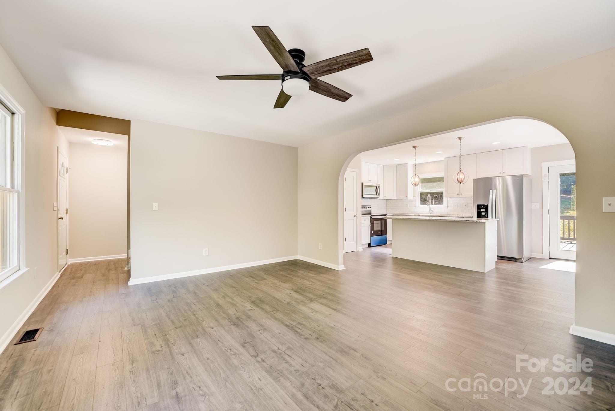 16218 Barbee Road Stanfield, NC 28163 - Photo 7 of 48 a view of empty room with wooden floor and ceiling fan