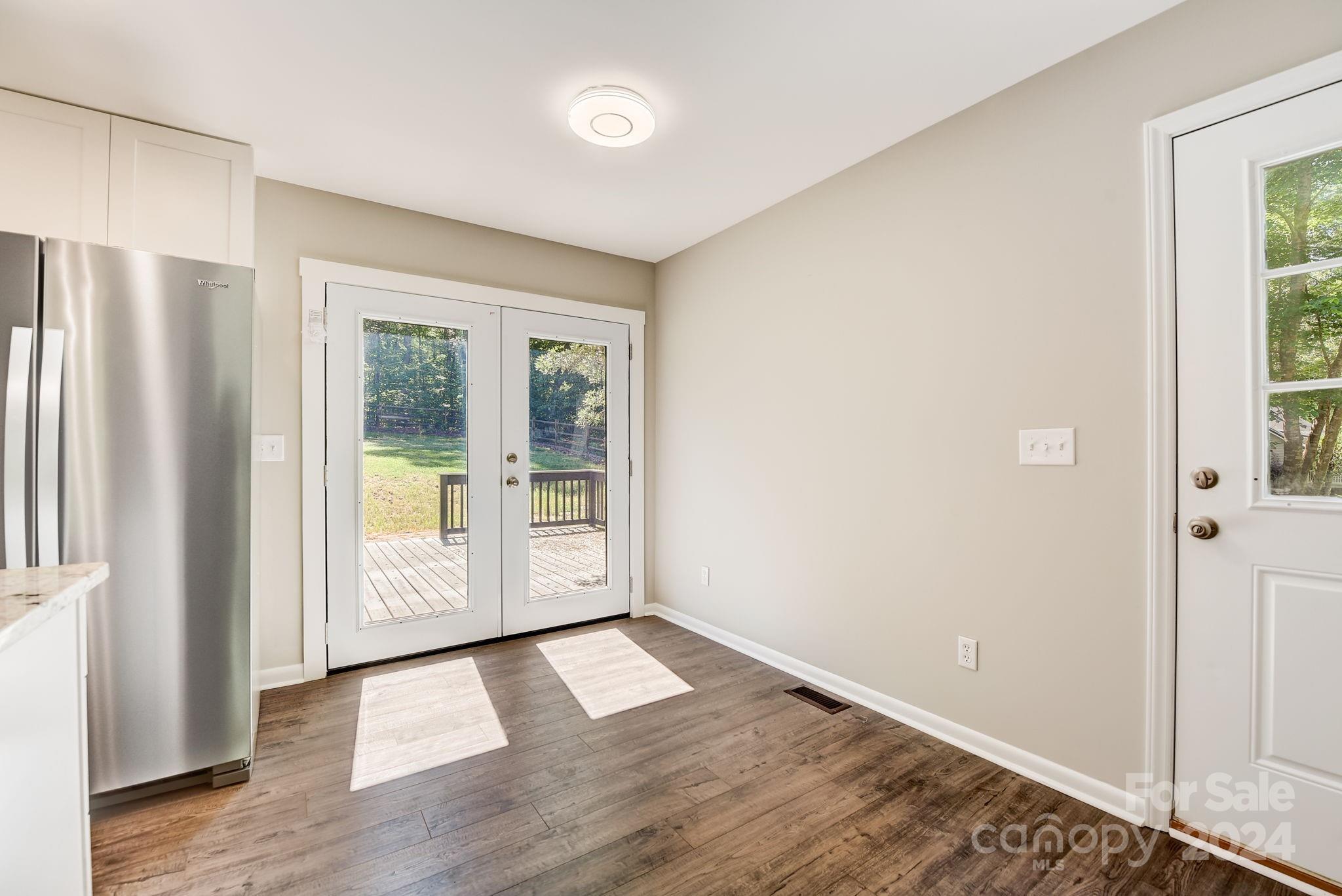 16218 Barbee Road Stanfield, NC 28163 - Photo 10 of 48 an empty room with wooden floor and windows