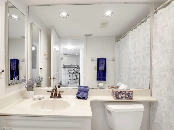 a bathroom with 2 sink toilet and a mirror