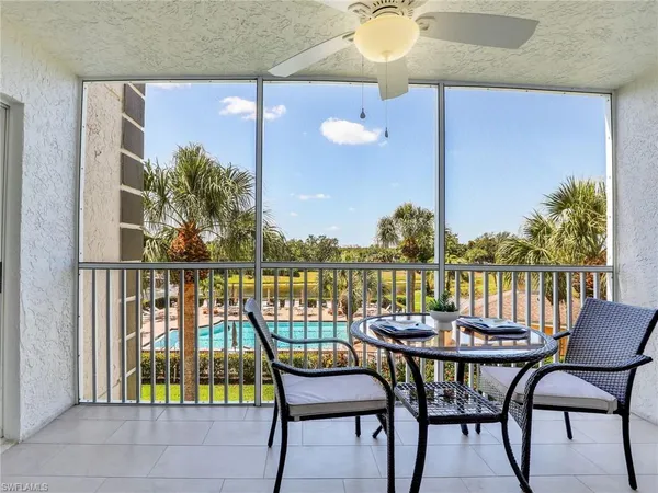 a view of a balcony with chairs and a potted plant