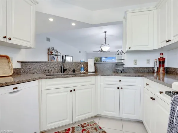 a kitchen with white cabinets and white appliances