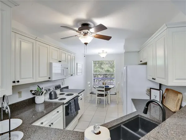 a kitchen with stainless steel appliances granite countertop a sink a stove and a refrigerator