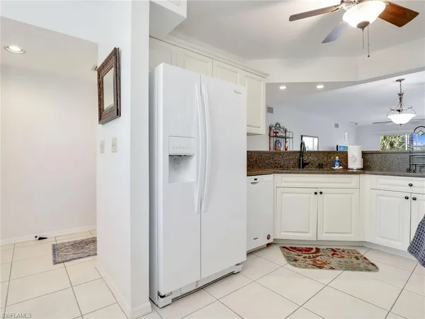 a room with kitchen island cabinets and stainless steel appliances