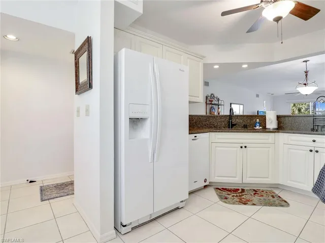 a room with kitchen island cabinets and stainless steel appliances