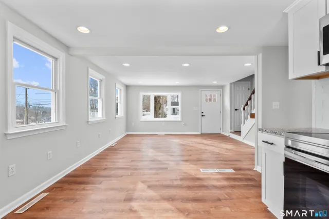 a view of an empty room with a window and fireplace