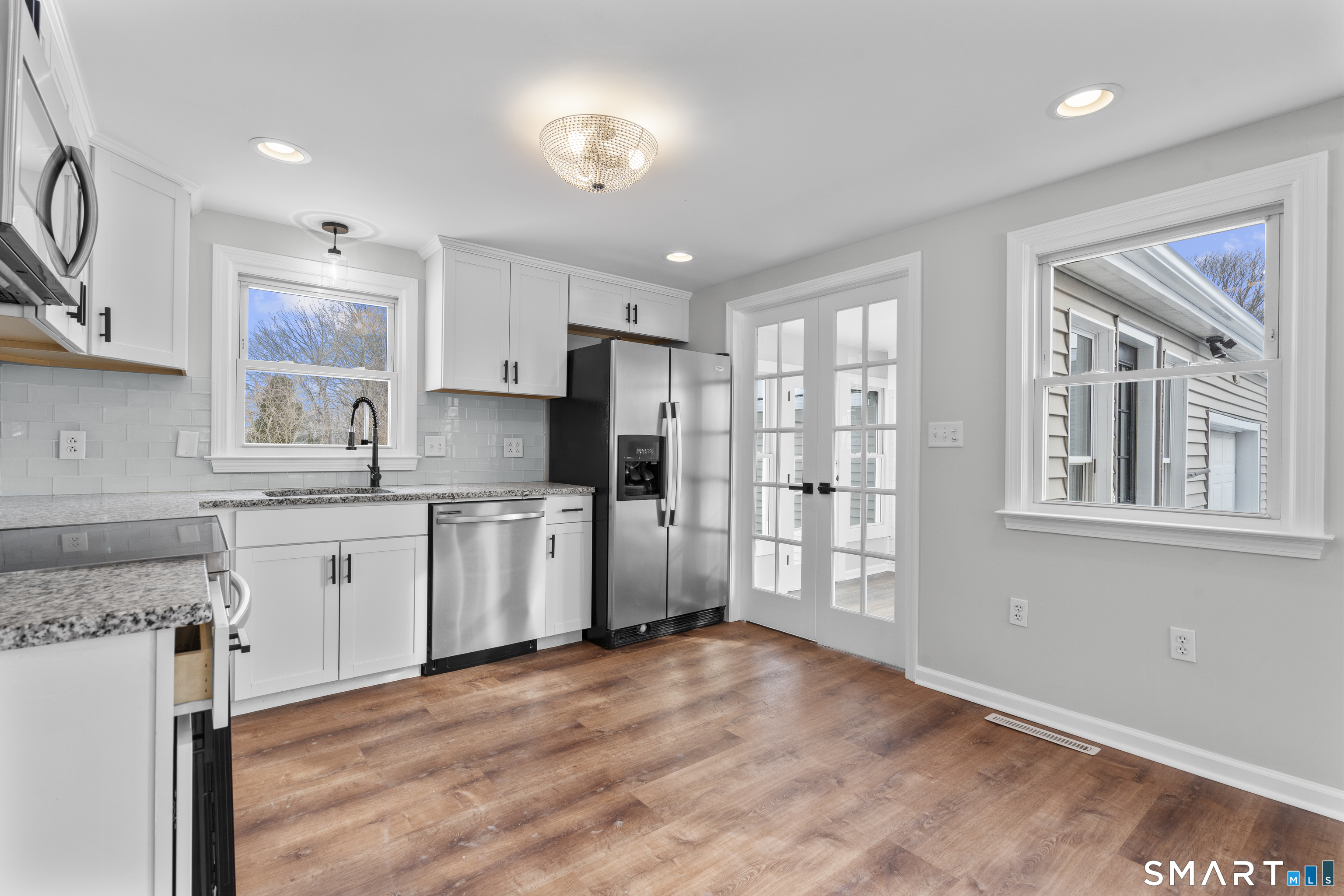 244 Curtiss Street Southington, CT 06489 - Photo 14 of 37 a kitchen with granite countertop a refrigerator oven a sink dishwasher and white cabinets with wooden floor