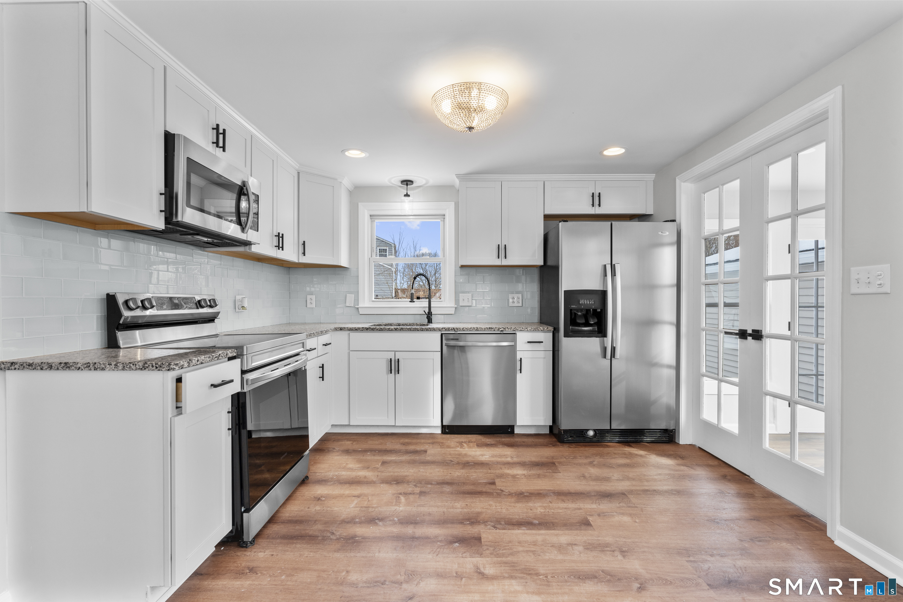244 Curtiss Street Southington, CT 06489 - Photo 15 of 37 a kitchen with stainless steel appliances granite countertop a refrigerator oven a sink dishwasher and white cabinets with wooden floor