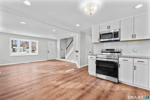 a kitchen with stainless steel appliances granite countertop a stove and a refrigerator