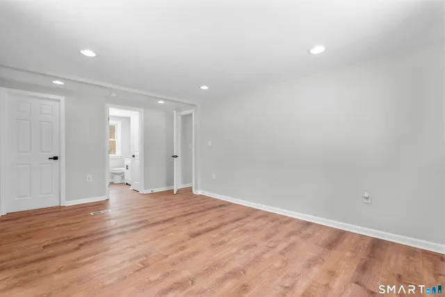 a view of an empty room with wooden floor