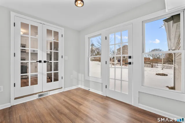 a view of empty room with wooden floor and windows