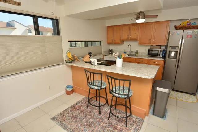 a kitchen with stainless steel appliances granite countertop a table chairs and a refrigerator