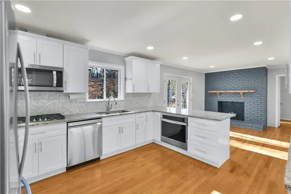a kitchen with granite countertop a stove top oven sink and cabinets