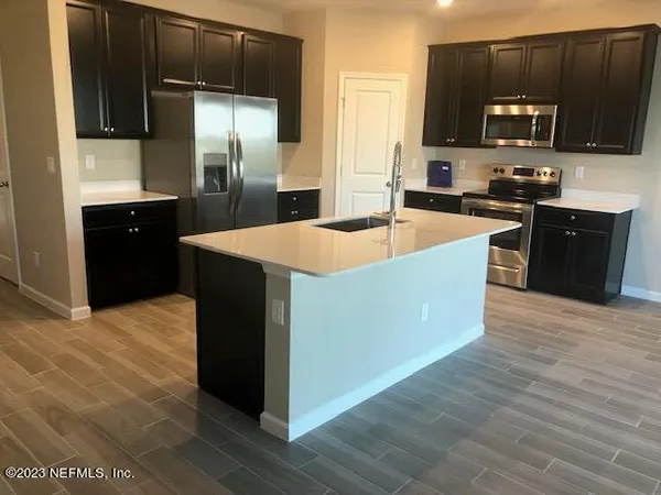 a kitchen with stainless steel appliances kitchen island granite countertop a refrigerator stove and microwave