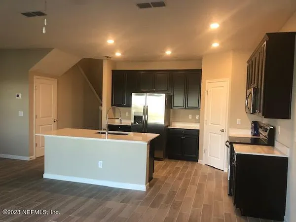 a large kitchen with stainless steel appliances a large counter top