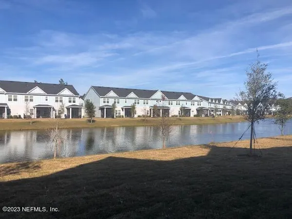 a view of house with river and trees in the background