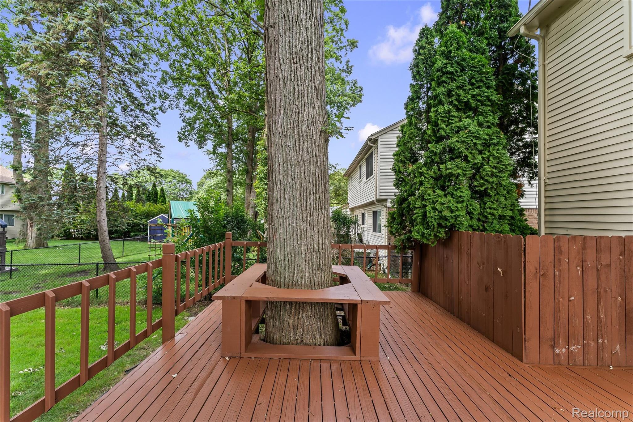 2118 Rutgers Drive Troy, MI 48085 - Photo 36 of 39 Expansive stained wood deck featuring a built-in tree bench and wood railing