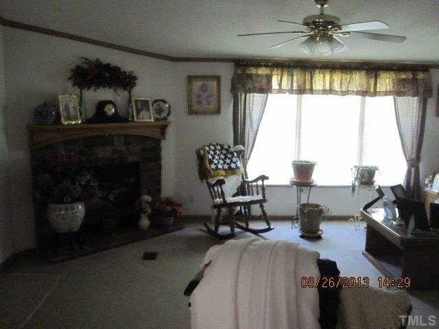 8603 South Creek Road Willow Spring, NC 27592 - Photo 3 of 7 a living room with furniture and a fireplace