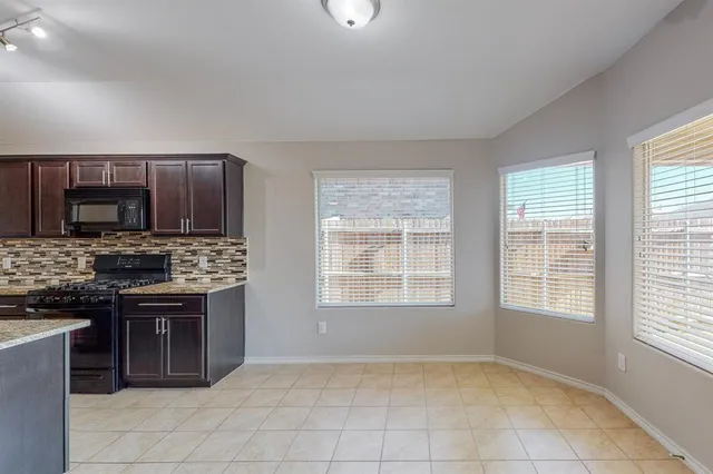 a view of kitchen with furniture and refrigerator